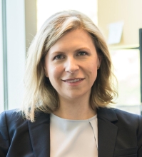 Laura Goodman wearing a black blazer and a white top.