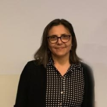 Tudorita Tumbar wearing a button-up shirt and a cardigan.
