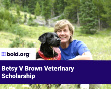 Betsy V Brown in a blue shirt with a black Labrador 