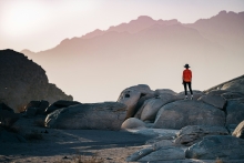 A person wearing a red shirt looking into at the landscape