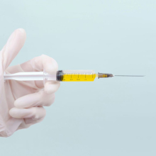 Gloved hand holding syringe