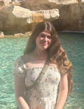 Emma Kosmeder smiling and standing in front of a pool of water