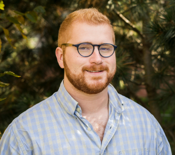 Photo of Jackson Seminara, man in blue shirt with glasses