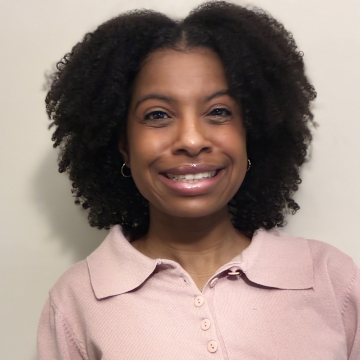 Maya Craig smiling in front of white wall