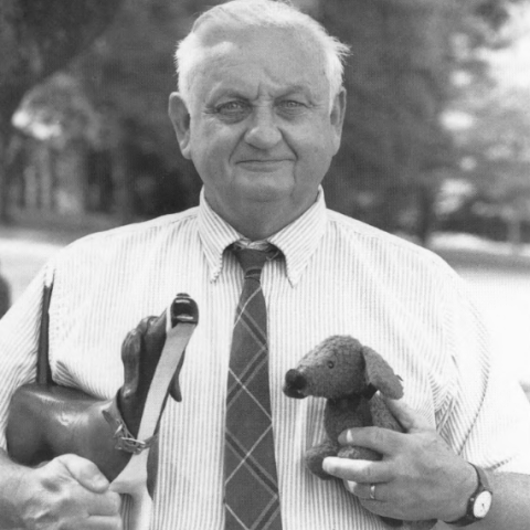 Dr, Skip Carmichael stands holding two dog models in his arms