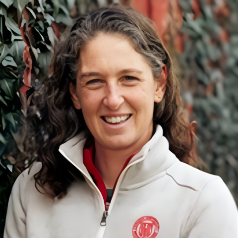 A woman with dark hair and a gray jacket. 