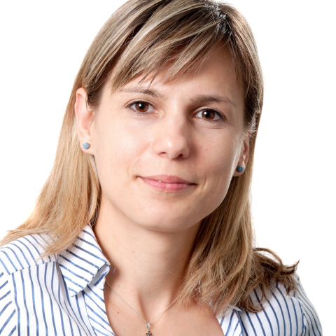A woman wearing a striped shirt against a white background. 