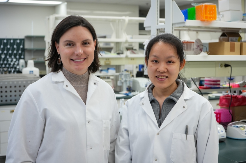 A photo featuring two researchers standing in the Evans Lab at the Baker Institute. 