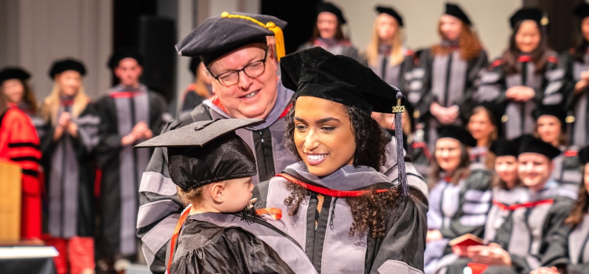 DVM Hooding ceremony, a student with a child in her arms