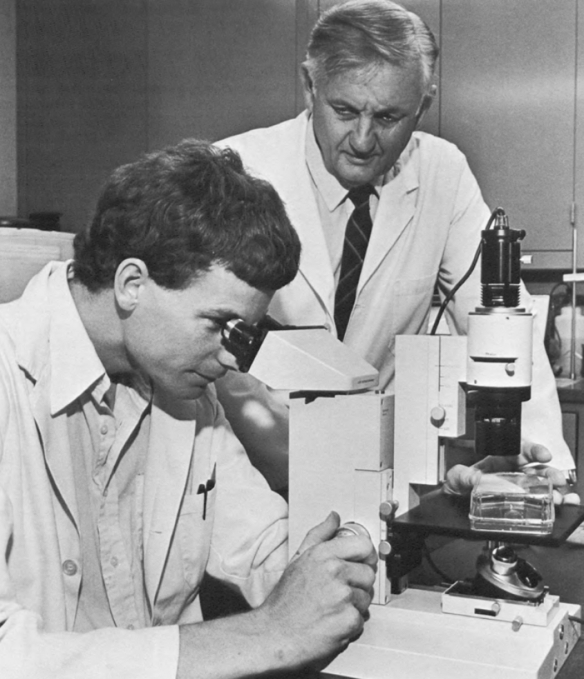 Two men working at the Baker Institute in lab coats. 