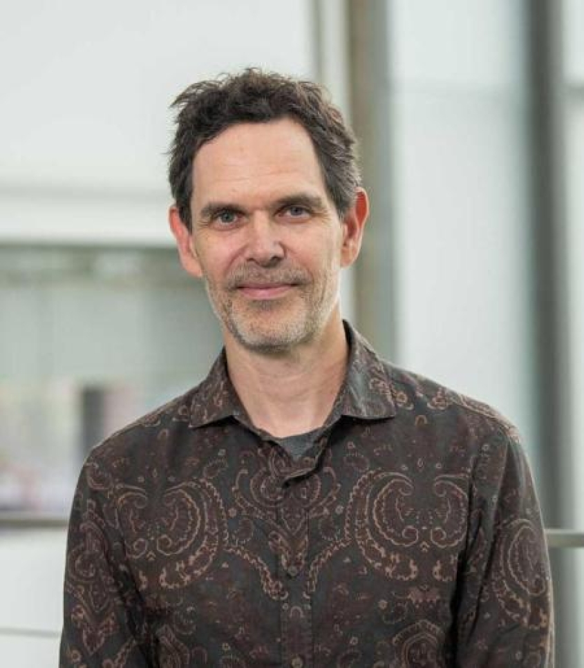 Brian Crane wearing a brown dress shirt with mandala design.
