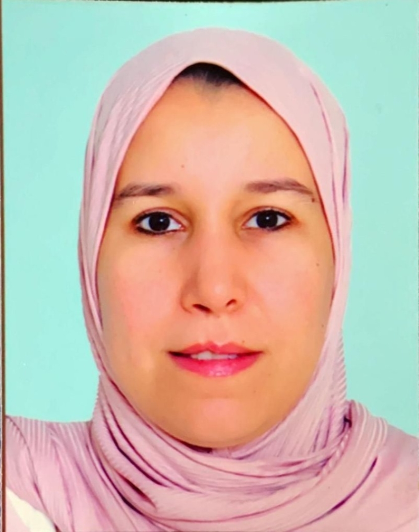 Portrait photograph of Dr. Meryem Outoli looking straight ahead at the camera in front of a mint green background