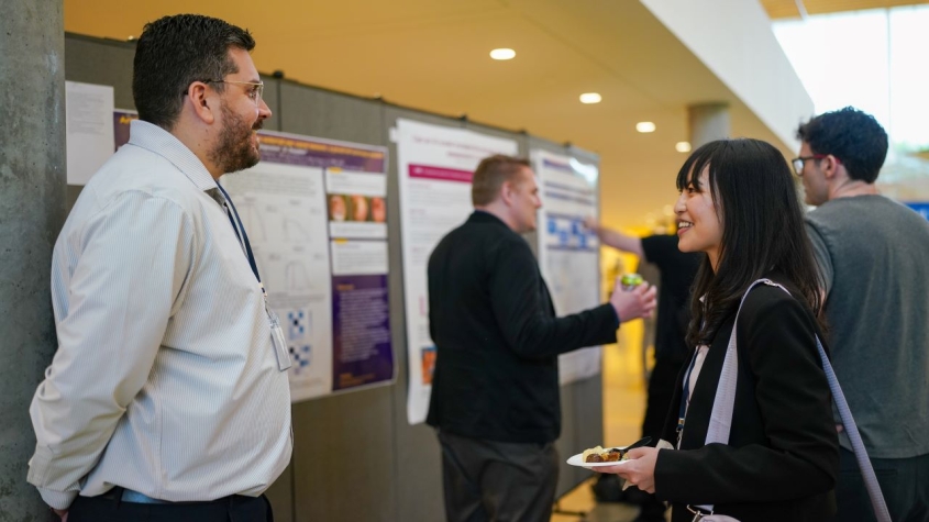 Two people talking in a poster session