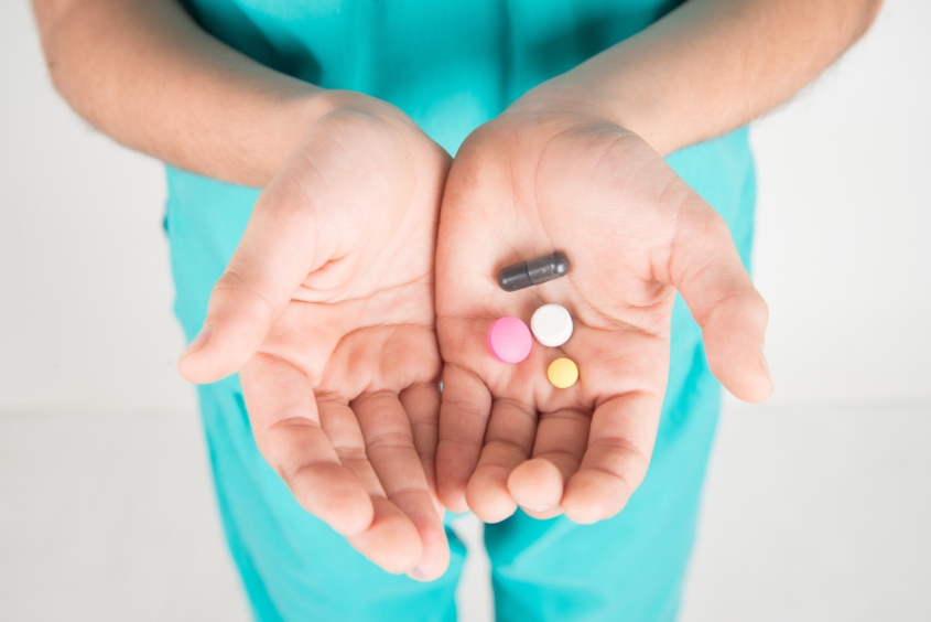 Cupped hands of a child holding antibiotic pills