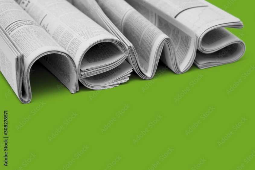 the word news written with folded newspapers