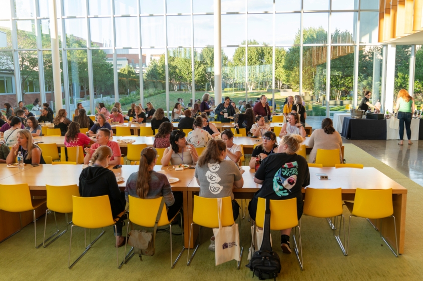 A crowd chatting at tables with food