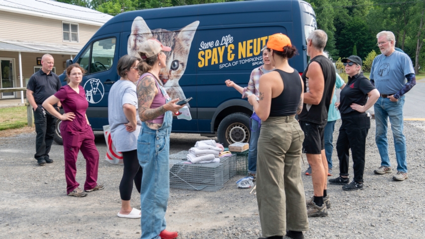 A group of people next to a truck marked with a logo that reads Spay/Neuter