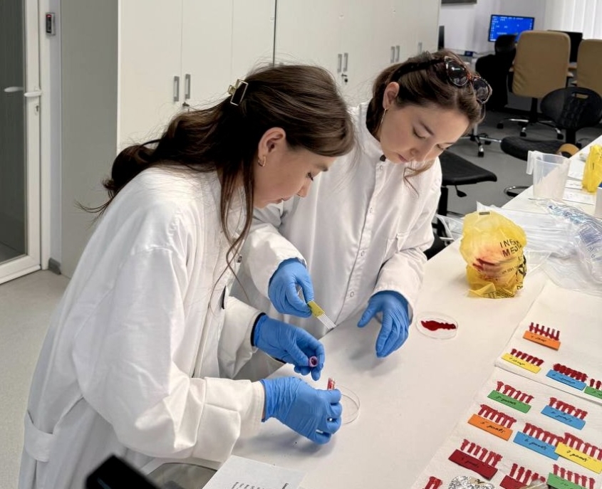 Two women in white coats at a lab bench