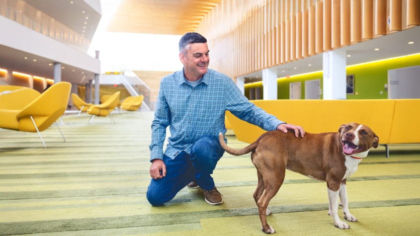 Adam Boyko with dog in CVM atrium