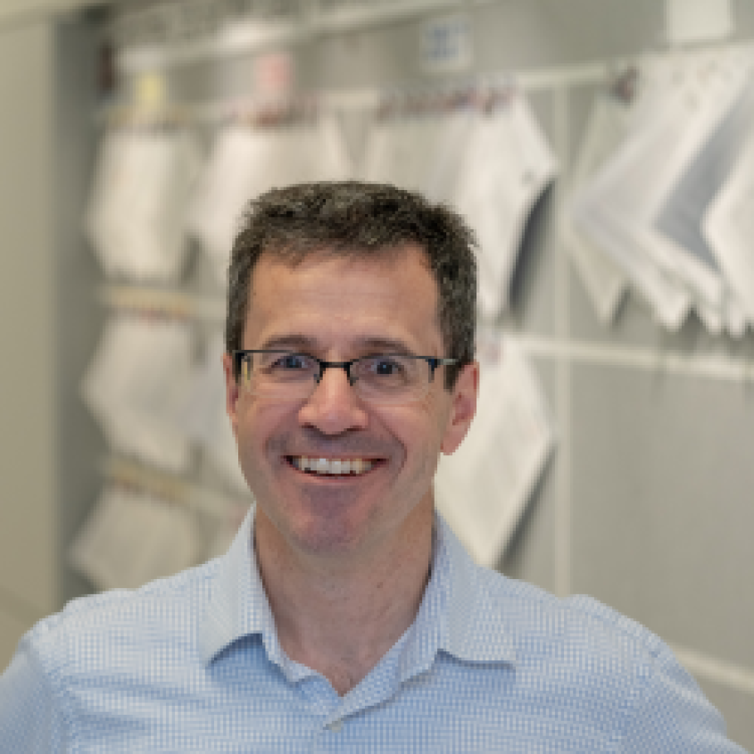 Martin Wiedmann in front of a bulletin board wearing a light blue-collared shirt.