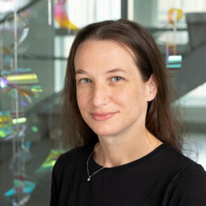 Julia Finklestein wearing a black top in front of the polychromic stringed artwork in MVR.
