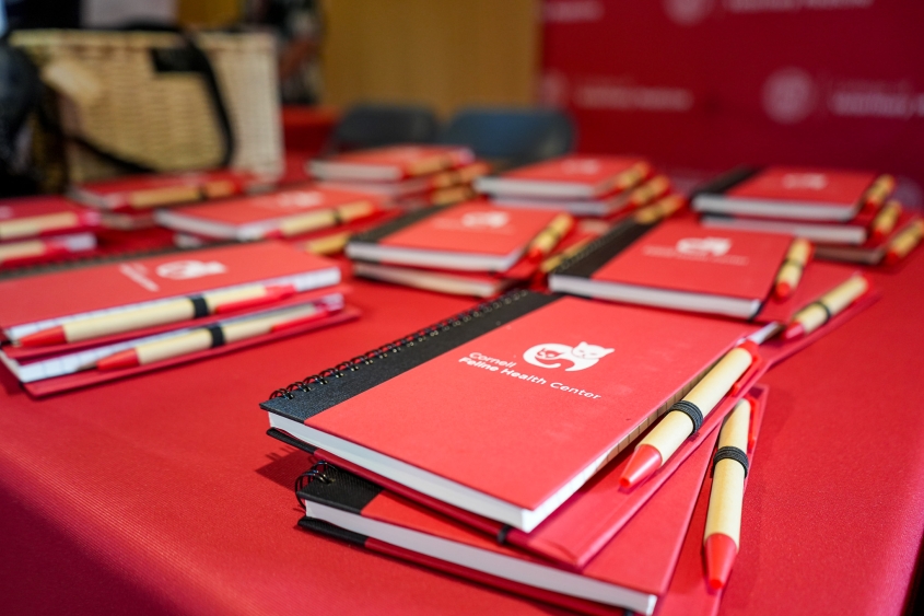 A group of red note books with an interlocking cat sits on a table. 