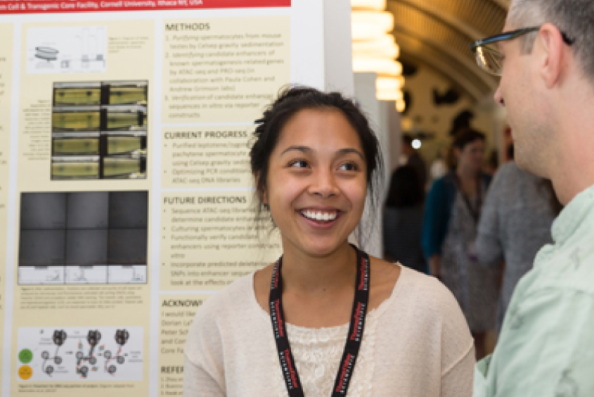 A student talking to an older person at a poster session