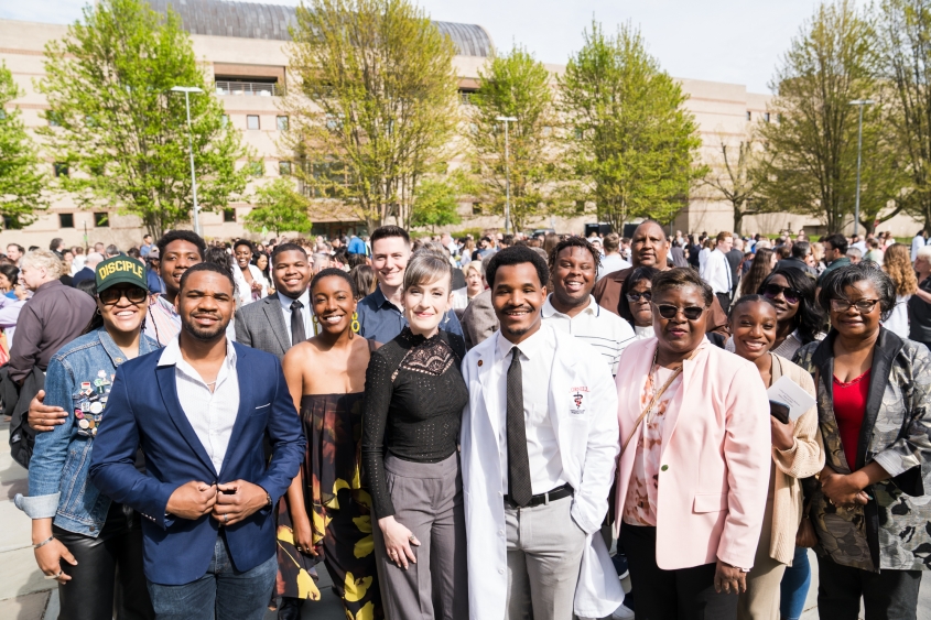 DVM alumna with family and friends pose for a photo.