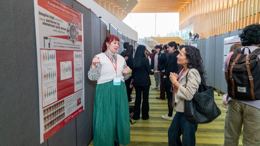 A researcher presenting their research at a poster session