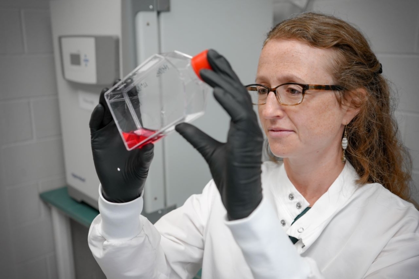 Sarah Caddy examining a container of red liquid