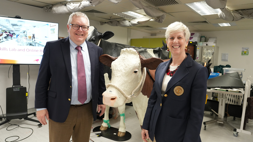 Warnick and Dean Barrs standing next to a cow model