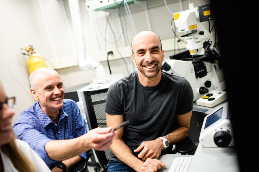 Alex Travis and Roy Cohen smiling in lab