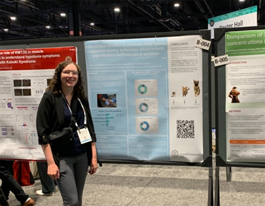 A woman stands in front of a research poster