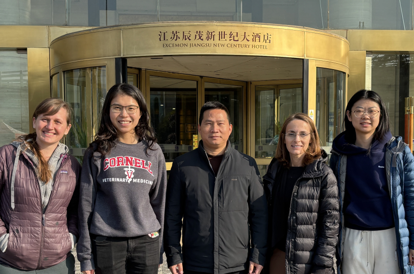 Five conference organizers posing in front of the conference hotel