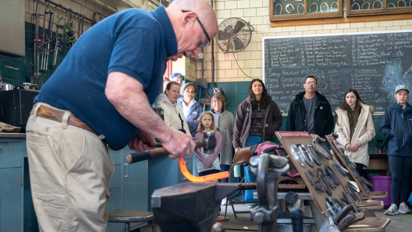 A farrier demonstrating making a horseshoe