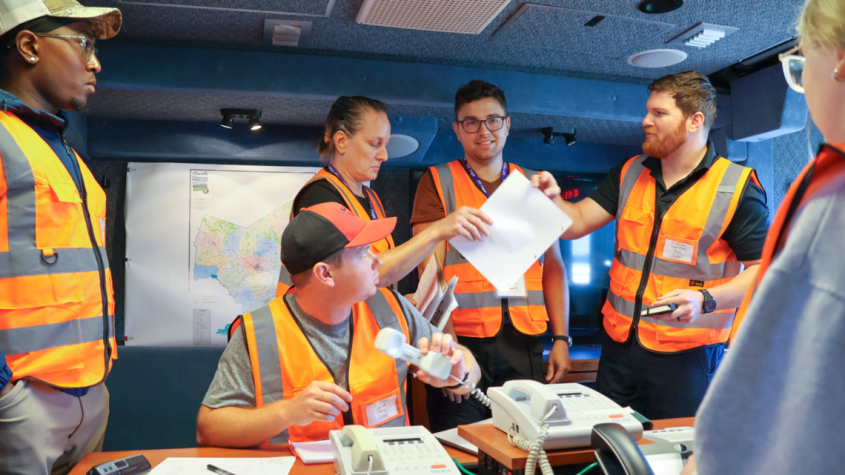 people in safety vests in a conference room