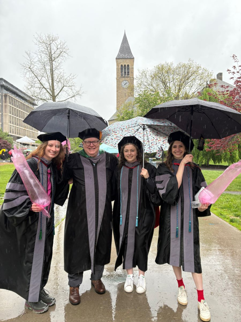 Dean Warnick and DVM students under umbrellas at commencement
