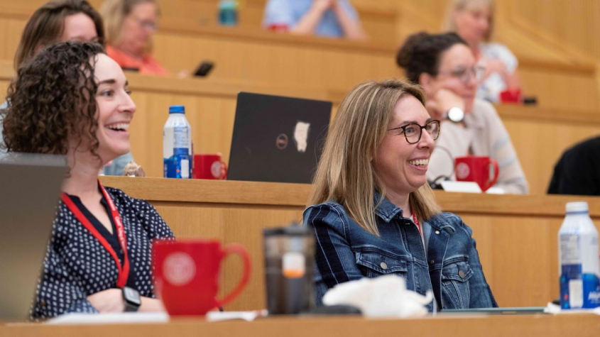 Conference attendees smiling in a lecture hall