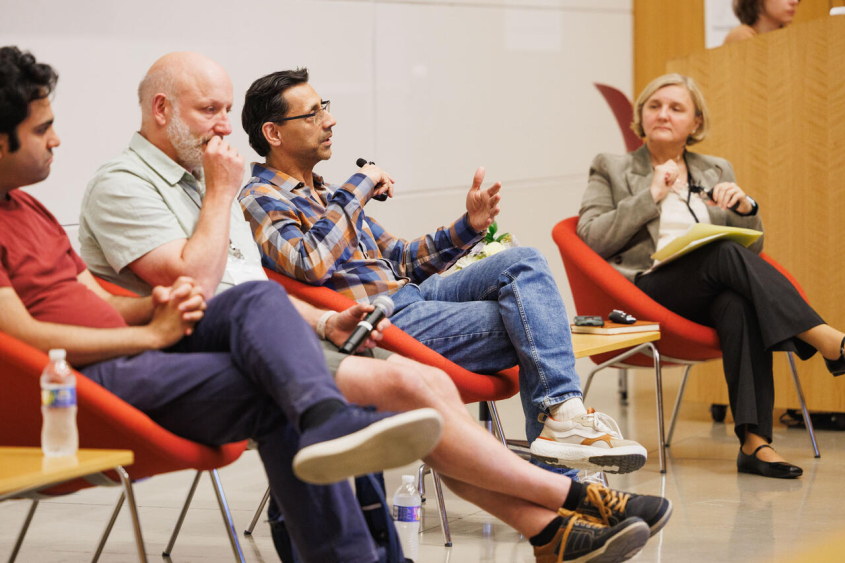 Panel discussion in large lecture hall.