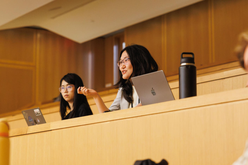 An audience member speaking from her seat in a lecture hall