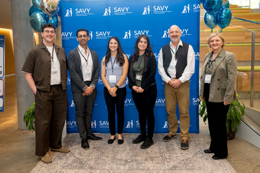 people posing in front of SAVY branded backdrop