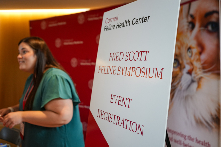 A sign reading Fred Scott Feline Symposium Event Registration 