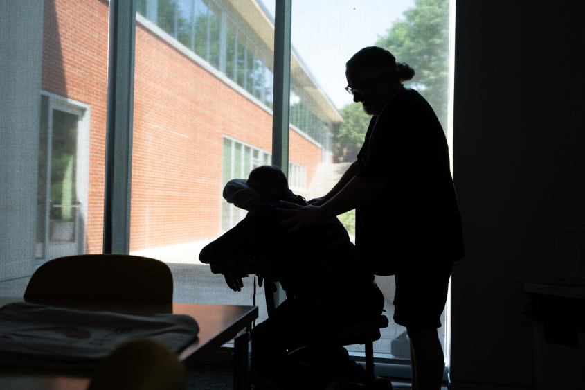 A silhouette showing a chair massage. 
