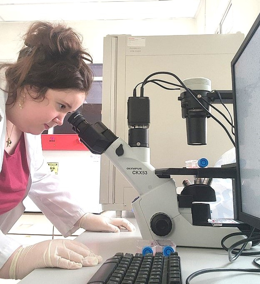 woman looking through microscope