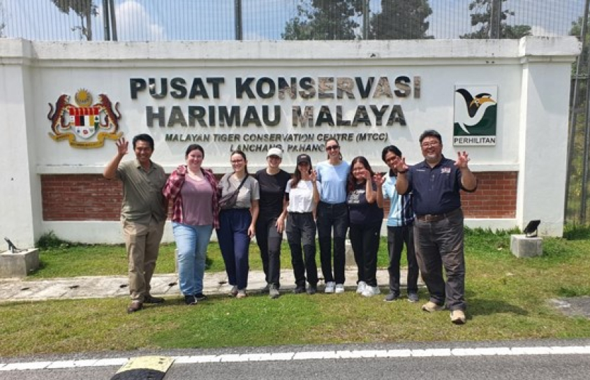 group of people in front of a sign