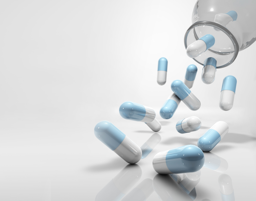 medicine capsules flying, falling out of glass container