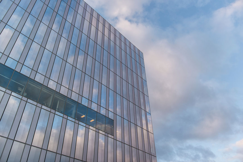 Exterior of Schurman Hall's glass walls against a blue sky