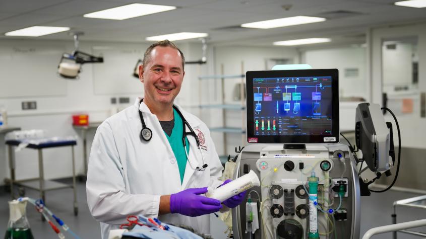 Dr. Jethro Forbes in front of the new extracorporeal blood purification unit at Cornell