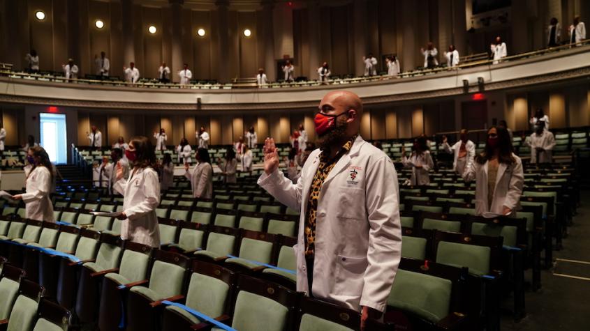 Veterinary students in white coats take the Veterinarian's Oath in Bailey Hall