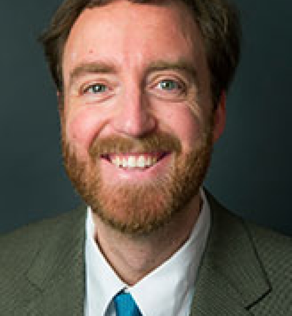 Charles Danko in grey suit and a blue tie.